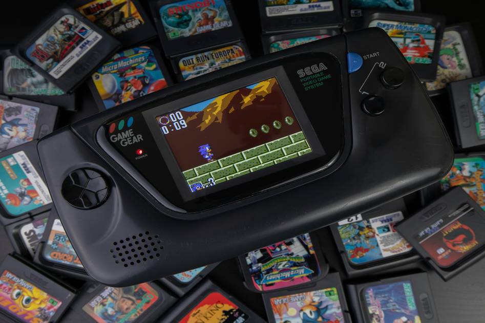 Two hands holding a high-end gaming tablet running a fast-paced shooter game